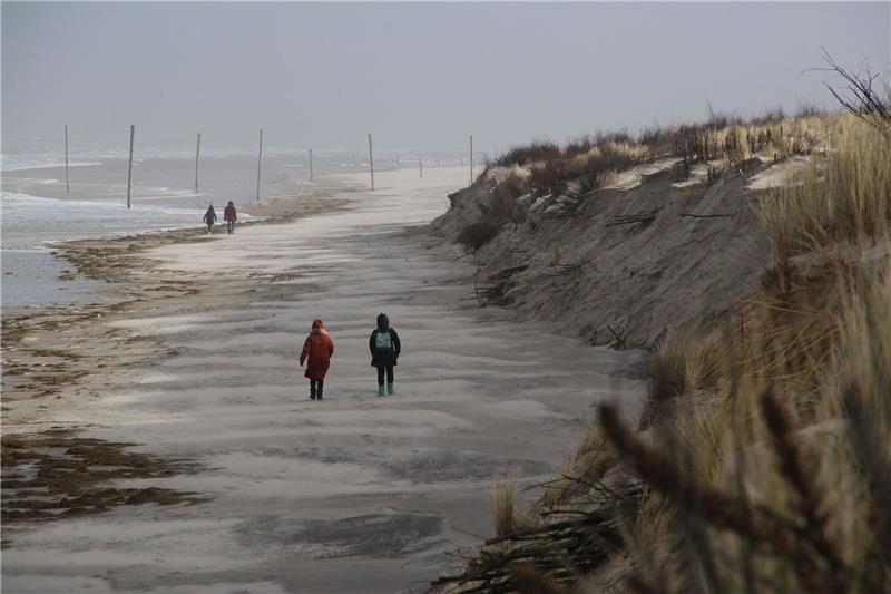 Sturmschäden: Inseln erwarten hohe Kosten für neue Strände Spaziergänger gehen an meterhohen Abbruchkanten am Strand der ostfriesischen Insel Wangerooge vorbei.