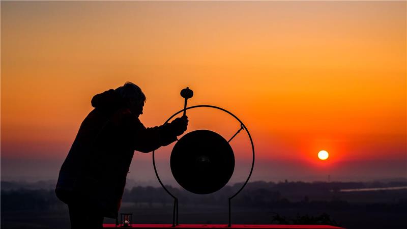  Künstlerin Heike Mildner schlägt zum Sonnenaufgang auf dem Krugberg in Seelow  einen Gong zum Gedenken an die Schlacht um die Seelower Höhen im April 1945. Vom 16. April um drei Uhr morgens bis zum Abend des 19. April wird dort ununterbrochen ein Gong angeschlagen - 87 Stunden lang, so lange wie die Schlacht um die Seelower Höhen idauerte. 