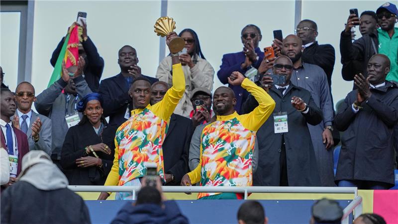  Senegalesische Spieler feiern mit der Afrika-Cup-Trophäe vor dem Spiel.
