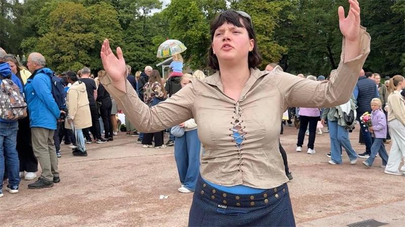 Gesichter der Trauer: So erinnern sich Norweger an Harald Sonya Lii Nome Barlow singt auf dem Schlossplatz ein Lied zu Ehren von Harald V.