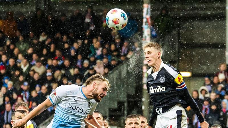 2. Liga in Kiel: Bernhardsson (r, Kiel) und Strompf (Bochum) kämpfen bei Regen um jeden Ball.