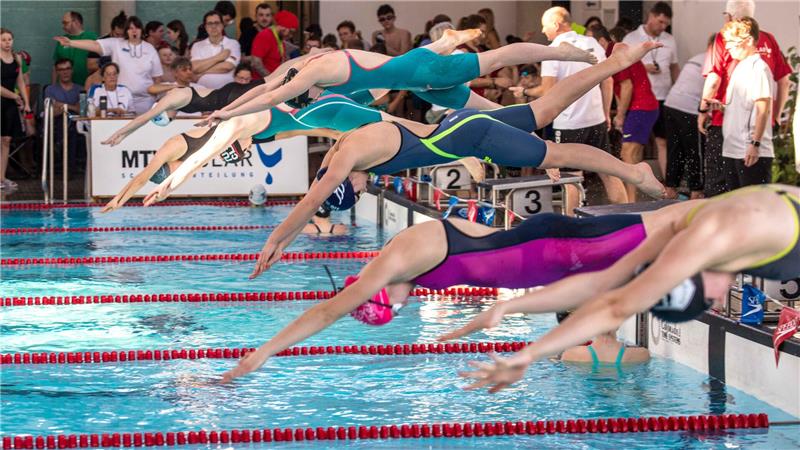 Aquantic Goslar: Weniger Freibadgäste, mehr Hallenbadbesuche Mehrere Menschen springen in ein Schwimmbecken.
