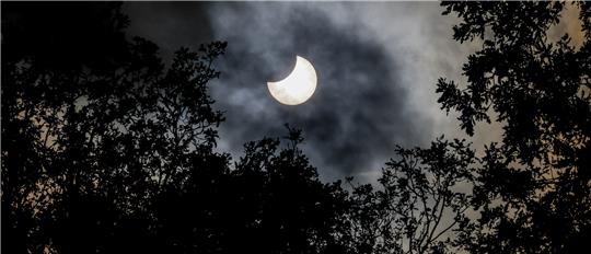 25.10.2022, Hamburg: Der Mond schiebt sich bei einer partiellen Sonnenfinsternis über dem Hamburger Stadtpark vor die Sonne. Die partielle Finsternis ist in Teilen Europas, Afrikas und Asiens zu sehen. Foto: Axel Heimken/dpa