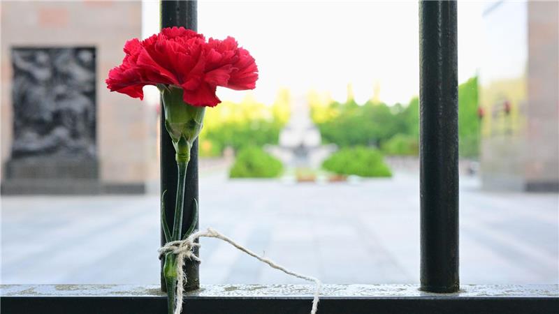 80. Jahrestag Ende Zweiter Weltkrieg – Berlin: Eine Blume hängt Zaun vor dem sowjetischen Ehrenmahl in der Schönholzer Heide.