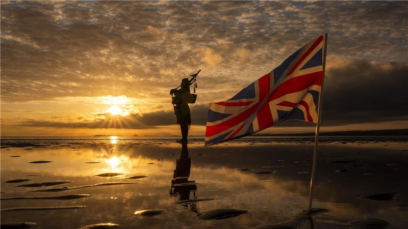 80. Jahrestag Ende Zweiter Weltkrieg - Edinburgh: Die schottische Nationalpfeiferin Louise Marshall spielt in der Morgendämmerung am Portobello Beach mit Blick auf den Firth of Forth ein Klagelied auf die Gefallenen zum 80. Jahrestag des Endes des Zweiten Weltkriegs.