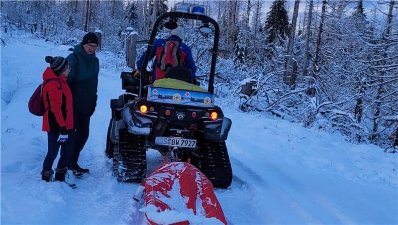 Ein Raupenfahrzeug zieht einen Schlitten durch den Schnee.