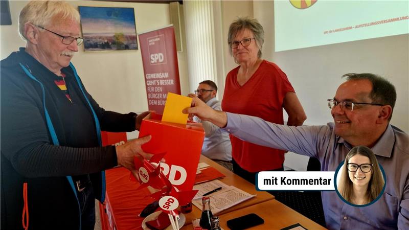 Vier Personen an einem Tisch mit roter SPD-Wahlurne, eine Person wirft einen Zettel ein, im Hintergrund SPD-Banner und Projektionsfläche.