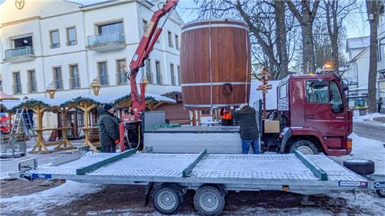Familie Zech lädt ein großes Fass per Kran auf einen Transporter.