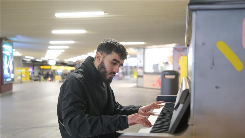 Nur wenige Syrer verlassen bisher Deutschland Abdul Rahman Al Ali aus Syrien spielt an einer U-Bahn Haltestelle in Stuttgart auf einem open Piano. Das Instrument ist dort für Jedermann zugänglich. (Archivfoto)