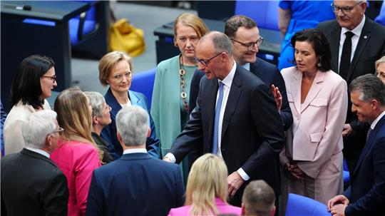 Abgeordnete gratulieren dem neu gewählten Bundeskanzler Friedrich Merz (Mitte) im Bundestag nach dem zweiten Durchgang der Kanzlerwahl.