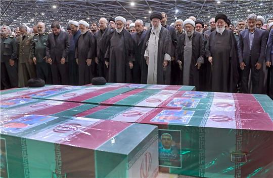 Abschied von Präsident Ebrahim Raisi, Außenminister Hussein Amirabdollahian und den weiteren beim Hubschrauberabsturz Getöteten: Irans Religionsführer Ajatollah Ali Chamenei (M.r.) spricht in Teheran an den mit Flaggen bedeckten Särgen ein Gebet.