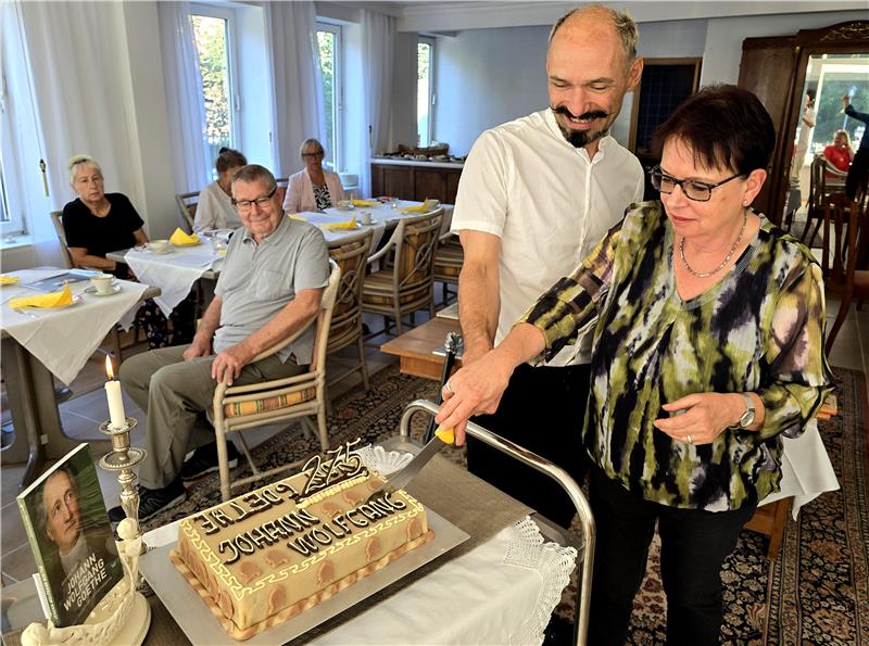 Achim Kapelle und Brigitte Wagener schneiden die Goethetorte an, die anschließend an den Tischen serviert wird.