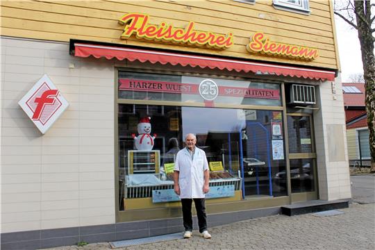 Achim Siemann steht vor der Fleischerei in Clausthal-Zellerfeld, die er im Jahr 1967 gekauft hat. Er blickt mittlerweile auf 70 Berufsjahre zurück und denkt noch lange nicht ans Aufhören. Foto: Jenzora