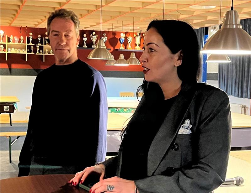 Zwei Menschen stehen an einem Tisch.