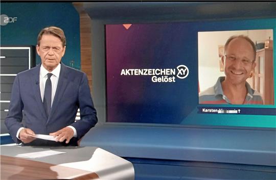 Aktenzeichen-XY-ungelöst-Moderator Rudi Cerne in der Sendung vom Mittwoch mit einem Foto von Karsten M. Foto: Screenshot