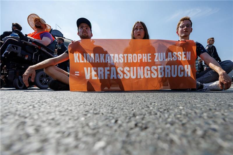 Aktivisten der Klimaschutzorganisation «Letzte Generation» protestieren bei einer Straßenblockade.