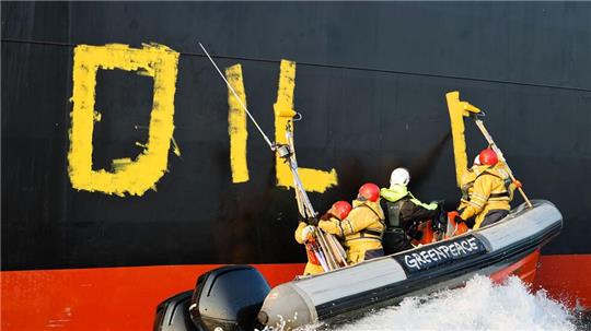 Aktivisten der Umweltorganisation Greenpeace malen den Schriftzug „Oil fuels war“ auf den Rumpf eines Schiffes, das russisches Öl auf der Ostsee transportiert. (Archivbild)