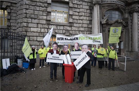 Aktivisten mit Masken von Wirtschaftsminister Habeck (l-r), Bauministerin Geywitz, Bundeskanzler Scholz und Verkehrsminister Wissing protestierten  vor dem Oberverwaltungsgericht Berlin.