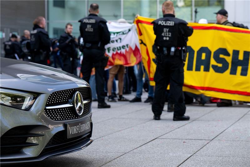 IAA-Proteste: Symbolische Hausbesetzung und Straßenblockade Aktivisten und Polizisten während einer Protestaktion vor einem Autohaus von Mercedes.