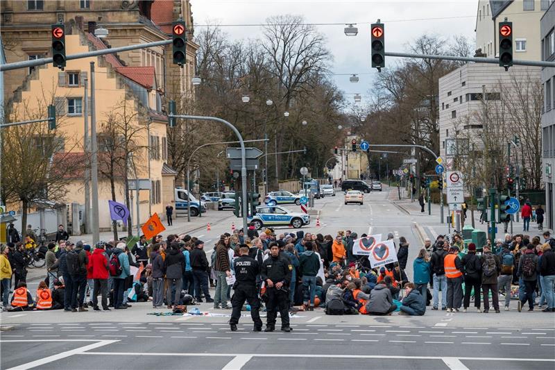 Klimaaktivisten protestieren mit Blockaden ohne Kleber Aktivistinnen und Aktivisten der Letzten Generation blockieren eine Kreuzung in Regensburg.