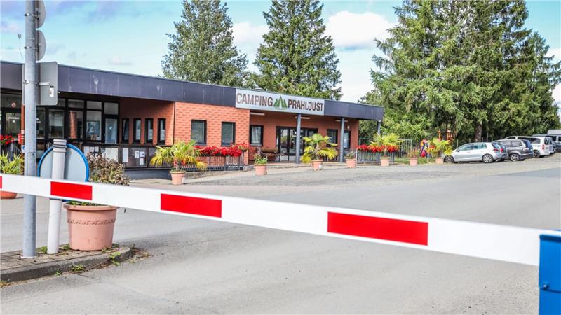 Zu sehen ist eine rot-weiße Schranke dir vor einem Gebäude steht.