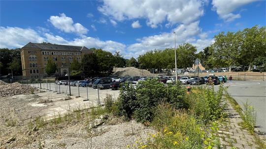 Das Bild zeigt die aktuelle Situation im Pfalzquartier: Im Vordergrund ein provisorischer Parkplatz, links und rechts sind Schotterhaufen.
