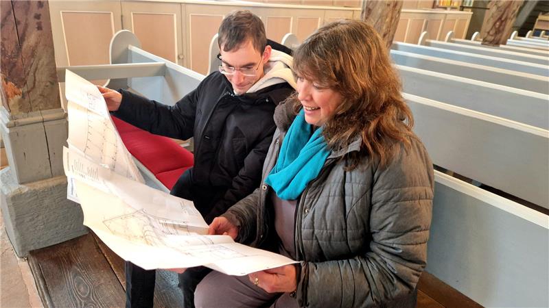 Alexander Pinnow und Gaby Mahnke aus dem Altenauer Kirchenvorstand studieren den Grundriss der St.-Nikolai-Kirche für die Planung der Brandmeldeanlage. 