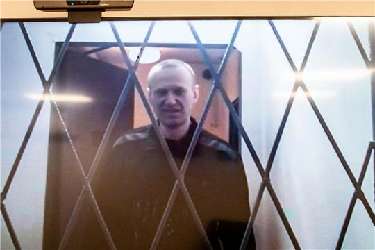 Alexej Nawalny ist auf einem Fernsehbildschirm zu sehen, als er per Video aus einem Gerichtssaal erscheint.