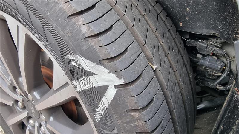 Eine Schraube ist in einen Autoreifen eingedreht.