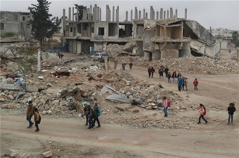 Hilfsorganisationen warnen vor Finanzkürzungen Alltag in Syrien: Kinder auf dem Rückweg von der Schule - sie laufen an Gebäuden vorbei, die durch Luftangriffe zerstört wurden.