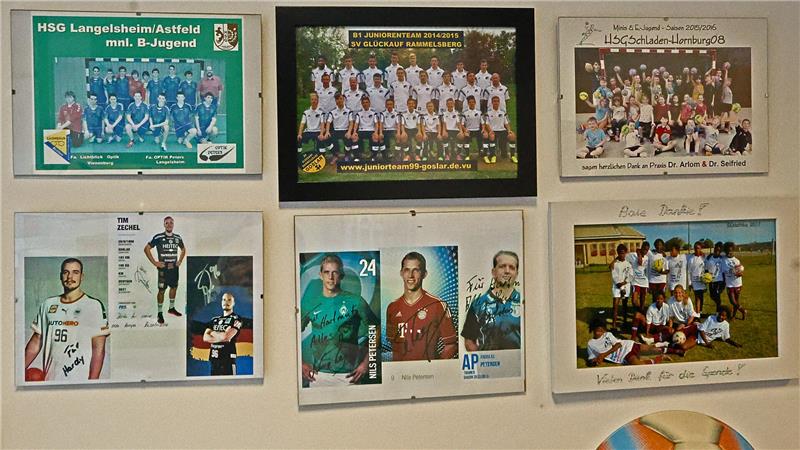 Wand mit sechs gerahmten Mannschaftsfotos und Autogrammen von Handballteams und Spielern, darunter Jugend- und Juniorenteams.