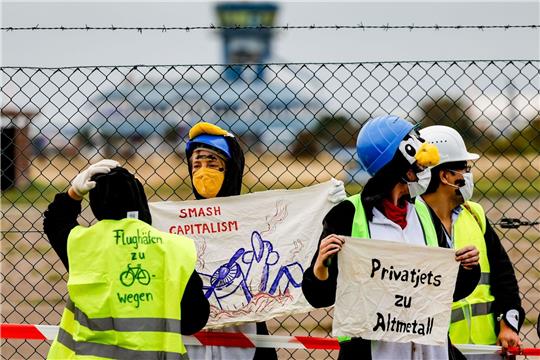 Als Pinguine verkleidete Aktivistin versuchen den Flughafen auf Sylt zu blockieren.