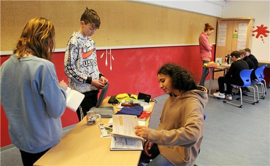 Als sogenannte Escape-Rooms richtet der Verein „Helden“ Schreibtische ein, an denen die Schüler – wie hier an der Oberschule Deilich – anhand von persönlichen Gegenständen und Notizen dem rätselhaften Verschwinden ihrer fiktiven Mitschüler spielerisch auf die Schliche kommen sollen und so die Geschichte aus der Sicht des anderen betrachten. Foto: Nachtweyh