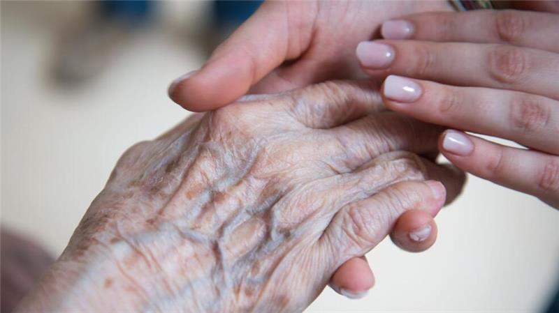 Alt und Jung: Eine Pflegerin hält die Hand einer Bewohnerin im Seniorenzentrum. Aber wie lange kann dieses Versorgungssystem noch funktionieren? (Symbolbild)