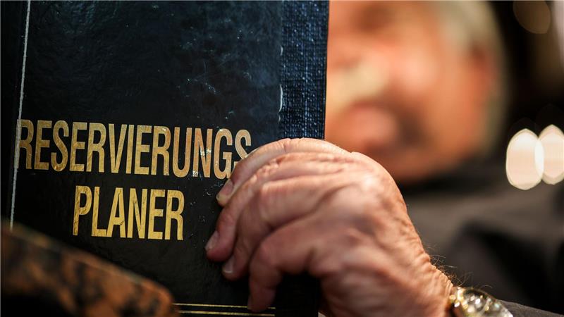 Wie die Gastronomie Gäste-Ghosting kontert Altmodisch? Ein Gastronom schaut in sein Reservierungsbuch.