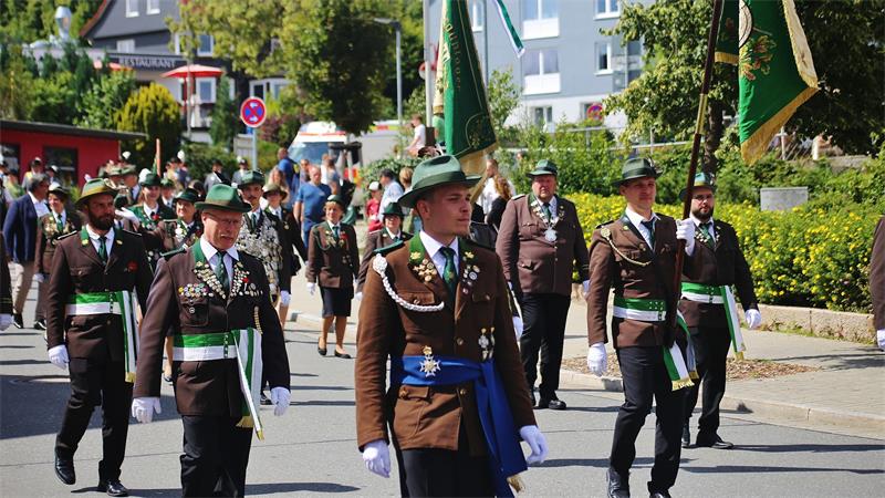 Das Foto zeigt eine Gruppe von Menschen in Uniform, die durch die Stadt marschieren.