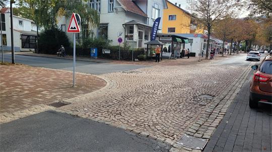 Das Bild zeigt einen Straßenabzweig, umgeben von Häusern.