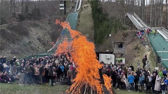 Am Fuße der Schanzen feiern die Menschen am Braunlager Osterfeuer.