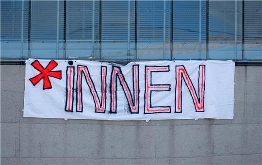 Auf einem Plakat steht ein Gendersternchen und der Zusatz "INNEN".