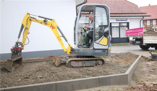 Am Lutteraner Finanzcenter, das Öffentliche und Landessparkasse beheimatet, sind Garten- und Landschaftsbauer mit einem Minibagger aktiv.
