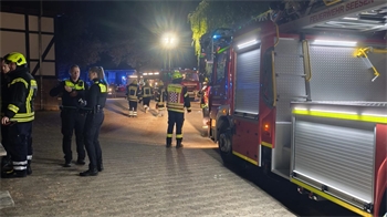 Mehrere Einsatzkräfte der Feuerwehr sind im Einsatz, die Drehleiter ist ausgefahren