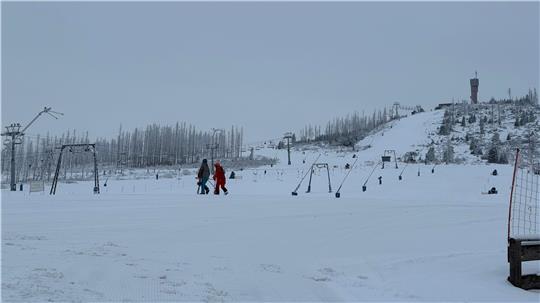 Das Bild zeigt zwei Skiläufer, die quer über die Skipiste am Hexenritt zum Schlepplift laufen.