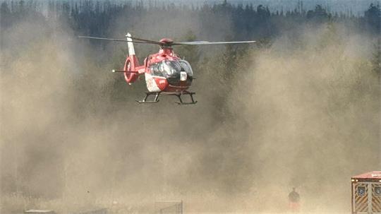Ein Rettungshubschrauber landet und wirbelt dabei Staub auf.
