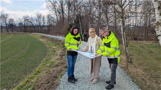 Am Schleusendamm in Wiedelah erläutern Dirk Sielaff, Fachdienstleiter Umwelt- und Gewässerschutz, und Teresa Klingenberg von der Unteren Wasserbehörde Oberbürgermeisterin Urte Schwerdtner (Mitte) die Sanierungsmaßnahmen.