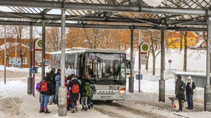Eine Menschentraube wartet auf Einlass in einen Bus der Linie 830.