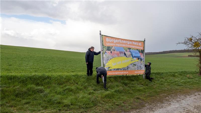 Am künftigen Standort des Solarparks Dörnten-Ost stellen die Mitglieder der Energiegenossenschaft bei widrigen Wetterverhältnissen eine Hinweistafel auf. Foto: Privat