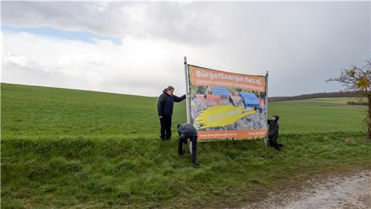Am künftigen Standort des Solarparks Dörnten-Ost stellen die Mitglieder der Energiegenossenschaft bei widrigen Wetterverhältnissen eine Hinweistafel auf. Foto: Privat