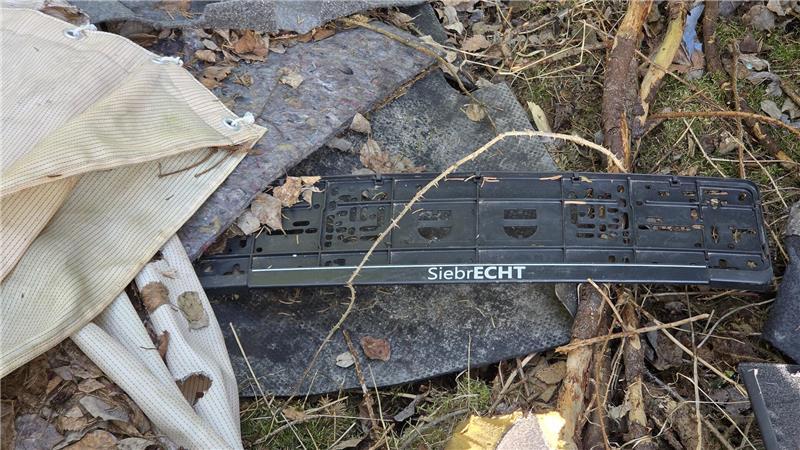 Teile eines alten Audis liegen im Wildemanner Wald. An dem Auto befand sich außerdem eine Kennzeichenhalterung mit der Aufschrift „SiebrECHT“.