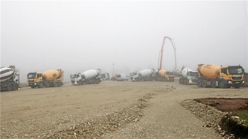 An der Betonpumpe reihen sich die Betonmischer auf, damit beständig für Nachschub beim Fundamentgießen gesorgt ist.