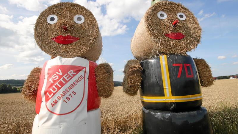 Lutteraner Doppel-Jubiläum wirft seine Schatten voraus An der Bundesstraße 248 werben zwei Strohpuppen für das Lutteraner Doppeljubiläum: TSV und Feuerwehr feiern am 9. und 10. August gemeinsam ihr 150-jähriges Bestehen.